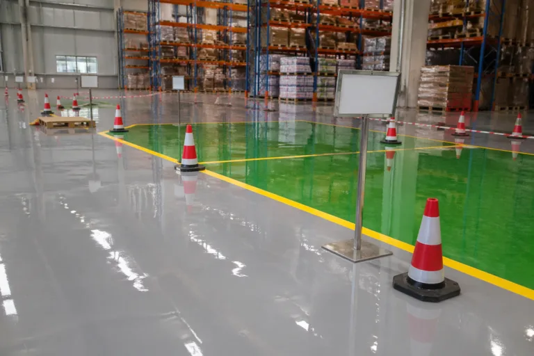 Clearly marked sections show different phases of epoxy floor cure time in a warehouse, illustrating safe traffic management during curing.
